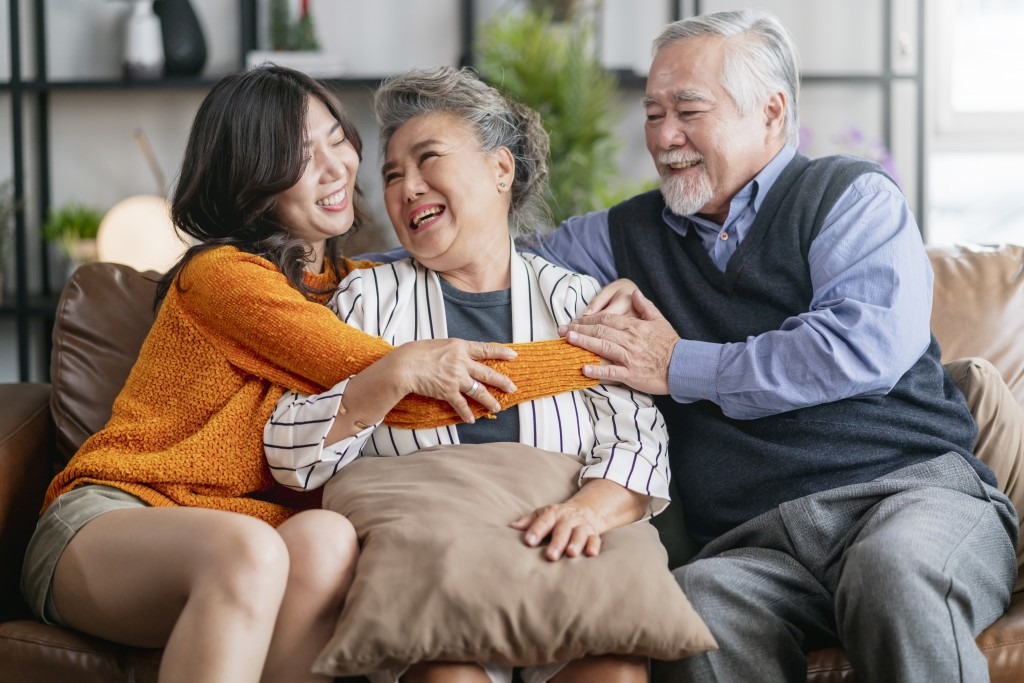 happiness asian family candid of daughter hug grandparent mother farther senior elder cozy relax on sofa couch surprise visiting in living room at home,together hug cheerful asian family at home