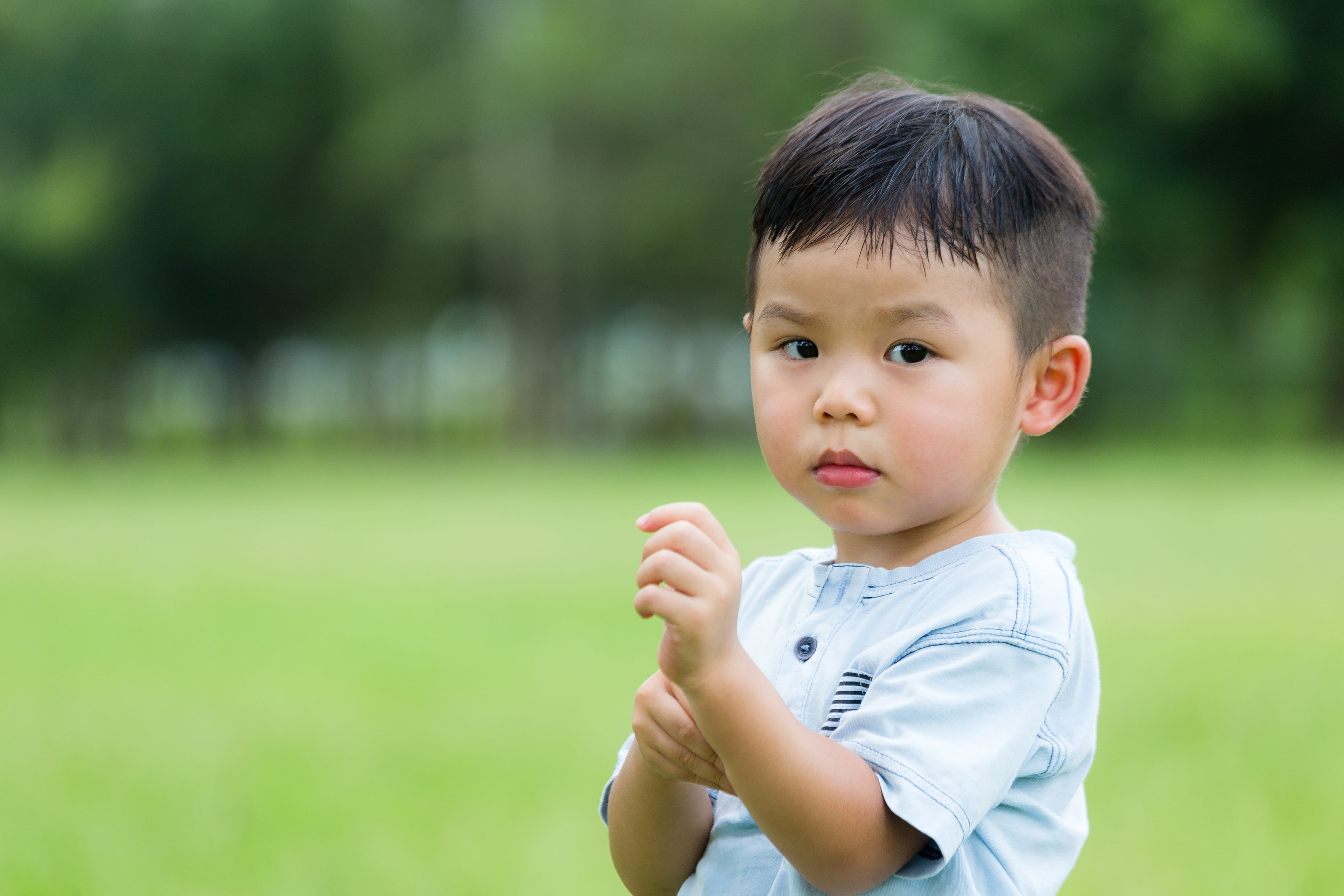 Asian kid scratching his arm